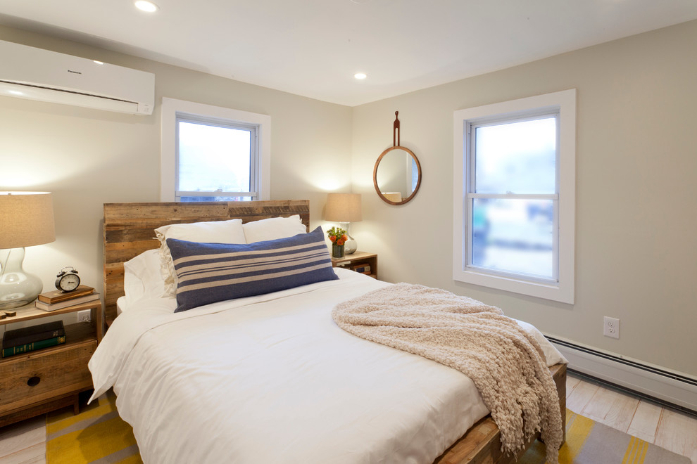 This is an example of a beach style master bedroom in New York with grey walls.