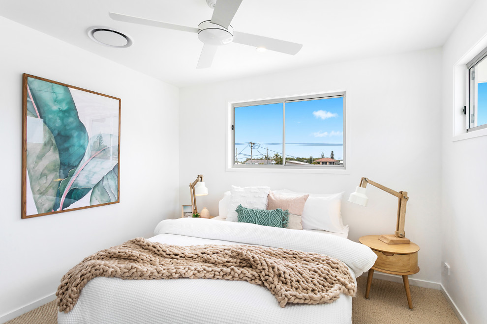 Photo of a beach style guest bedroom in Central Coast with white walls, carpet, no fireplace and brown floor.