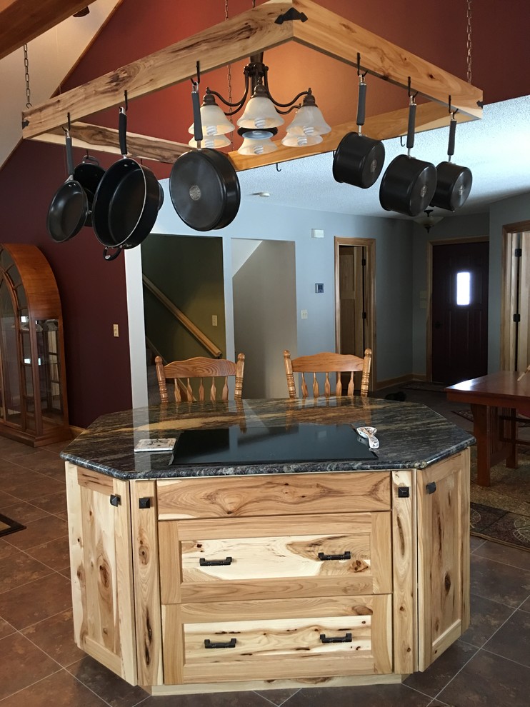Inspiration for a large rustic galley porcelain tile and brown floor eat-in kitchen remodel with a double-bowl sink, shaker cabinets, light wood cabinets, quartzite countertops, gray backsplash, stone slab backsplash, black appliances and an island