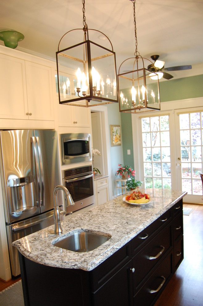 Inspiration for a transitional u-shaped eat-in kitchen remodel in Raleigh with an undermount sink, recessed-panel cabinets, white cabinets, quartzite countertops, white backsplash, subway tile backsplash and stainless steel appliances
