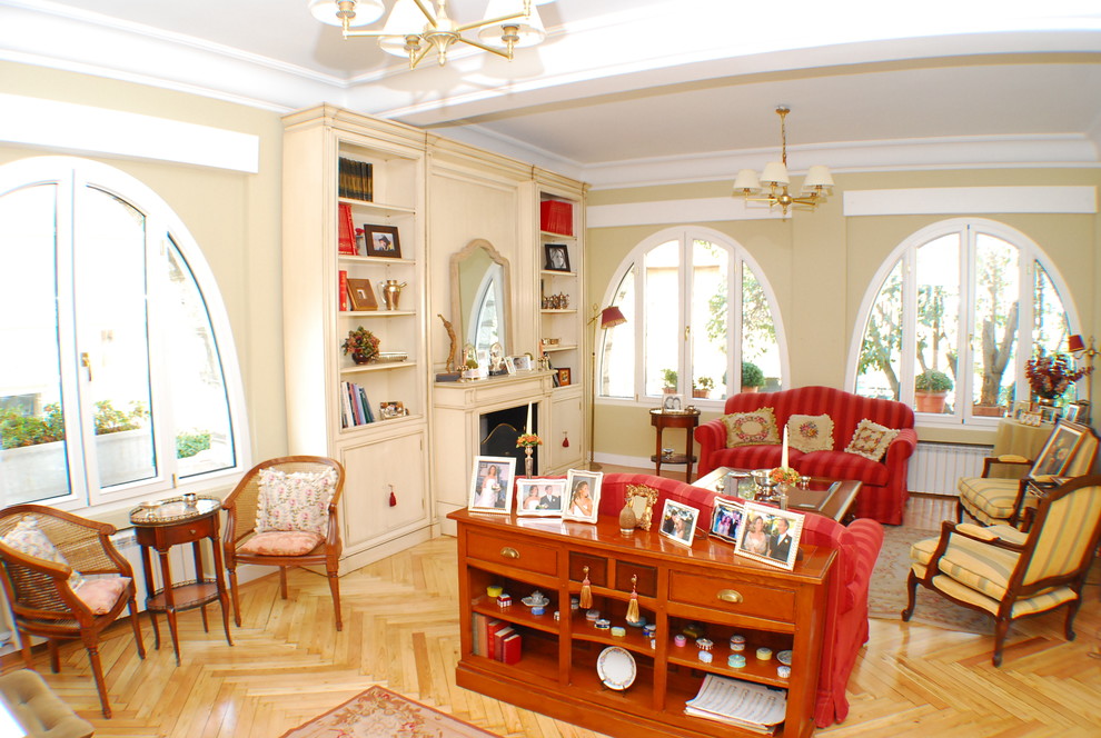 Example of a mid-sized classic medium tone wood floor living room design in Madrid with a standard fireplace and a wood fireplace surround