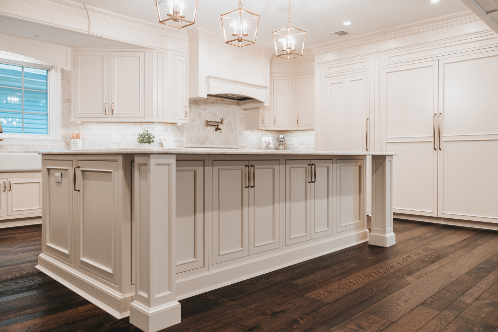 Design ideas for a large classic l-shaped kitchen/diner in New York with a belfast sink, beaded cabinets, white cabinets, integrated appliances, dark hardwood flooring and an island.