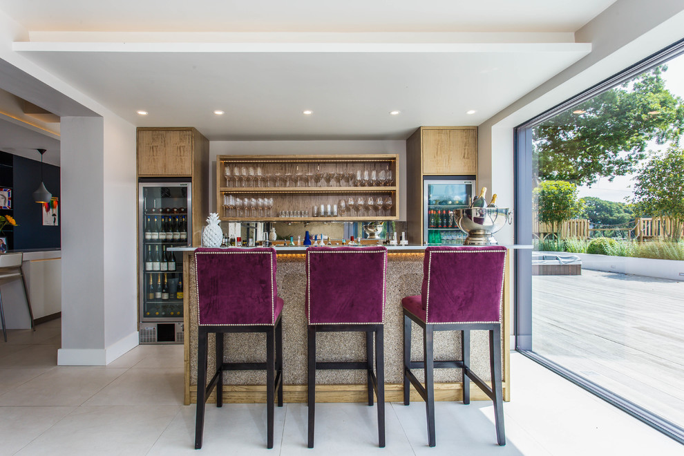 This is an example of a transitional seated home bar in Sussex with open cabinets, light wood cabinets and beige floor.