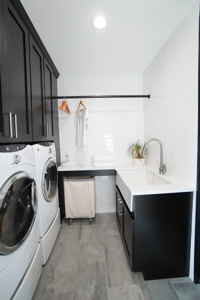 Inspiration for a large contemporary laundry room in Atlanta with flat-panel cabinets, black cabinets, grey walls, porcelain floors and grey floor.