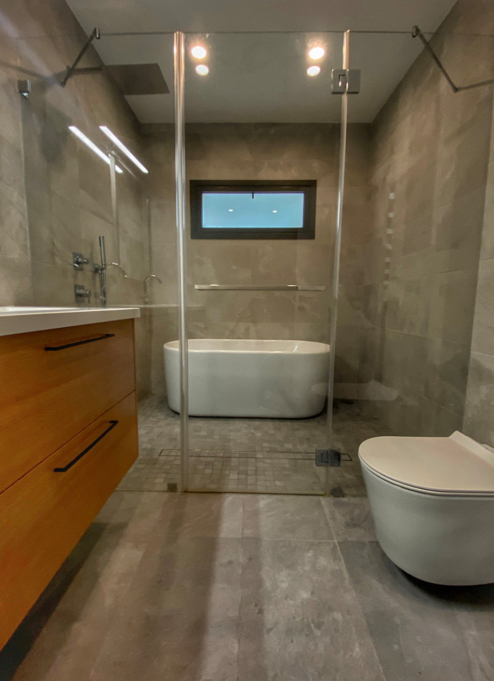 Photo of a mid-sized contemporary 3/4 bathroom in Los Angeles with flat-panel cabinets, medium wood cabinets, a curbless shower, a one-piece toilet, grey walls, porcelain floors, an undermount sink, grey floor, a hinged shower door and white benchtops.