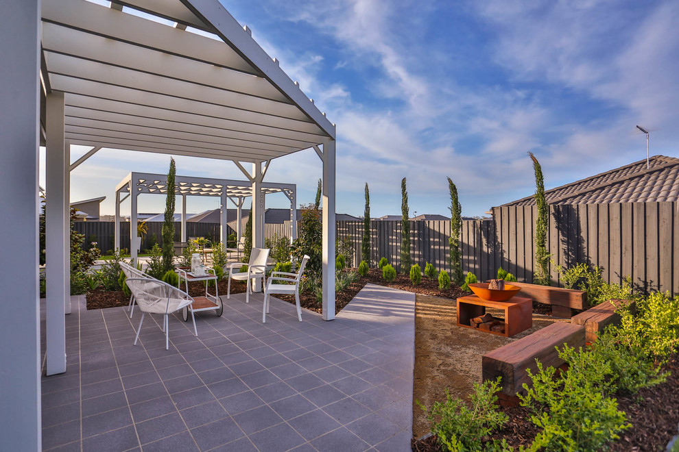 This is an example of a contemporary backyard garden in Brisbane with a fire feature.