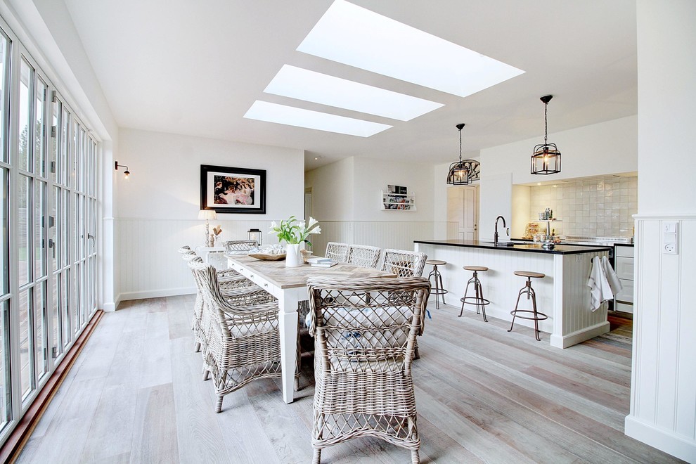 Photo of a large beach style kitchen/dining combo in Copenhagen with light hardwood floors, beige floor, white walls and no fireplace.