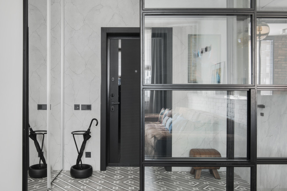 Foto på en liten industriell ingång och ytterdörr, med grå väggar, klinkergolv i keramik, en enkeldörr, en svart dörr och grått golv