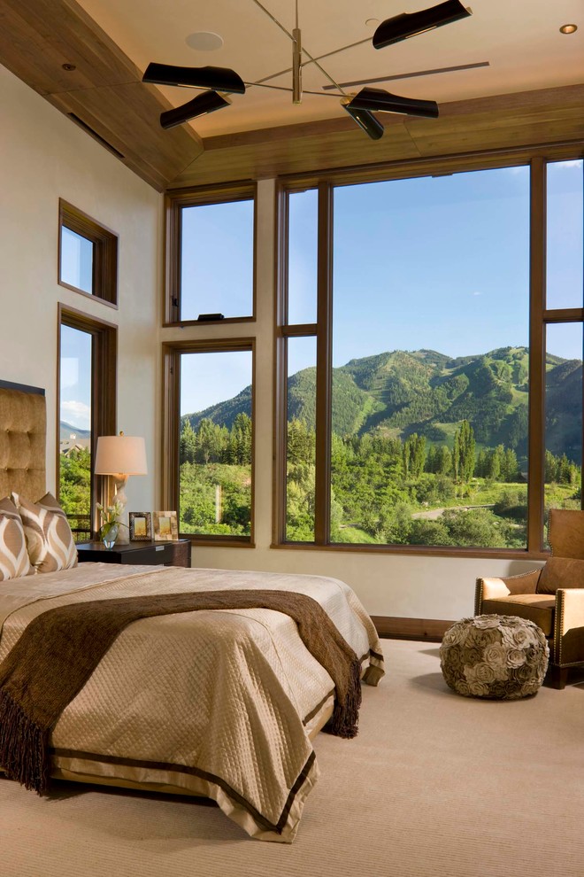 This is an example of a contemporary bedroom in Denver with beige walls and carpet.