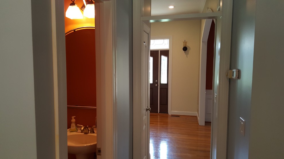 Mid-sized medium tone wood floor hallway photo in Raleigh with beige walls