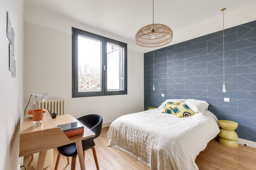 This is an example of a midcentury guest bedroom in Paris with grey walls, light hardwood floors and beige floor.