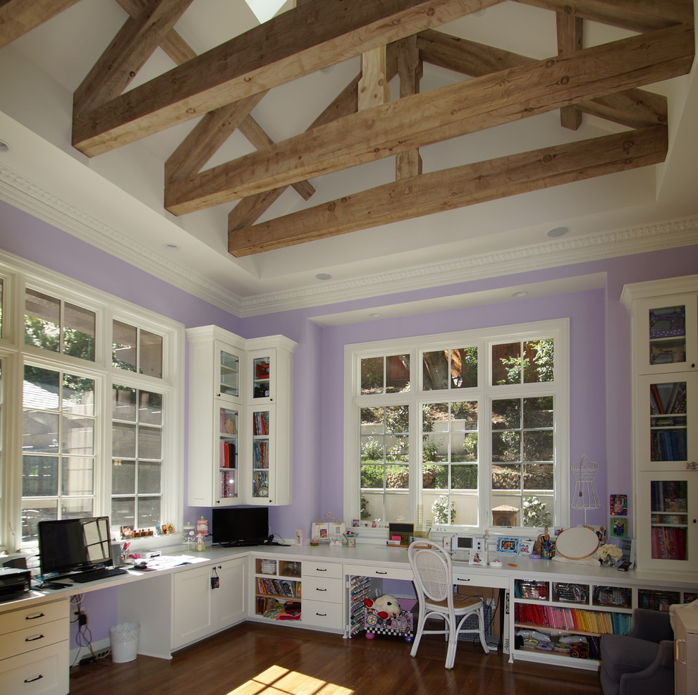 Design ideas for a large craft room in San Francisco with purple walls, dark hardwood floors and a built-in desk.