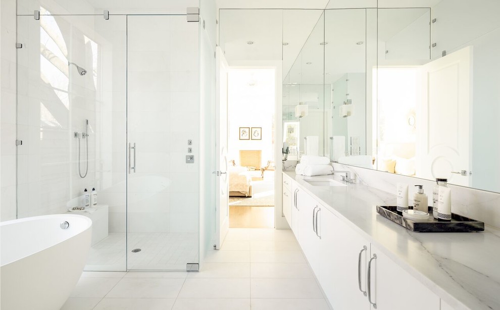 Design ideas for a large transitional master bathroom in Dallas with flat-panel cabinets, white cabinets, a freestanding tub, a corner shower, white walls, ceramic floors, an undermount sink and marble benchtops.