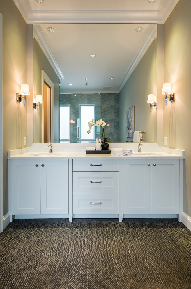 Corner shower - huge rustic 3/4 gray tile and stone tile marble floor and gray floor corner shower idea in Vancouver with shaker cabinets, white cabinets, a two-piece toilet, gray walls, an undermount sink, solid surface countertops, a hinged shower door and white countertops