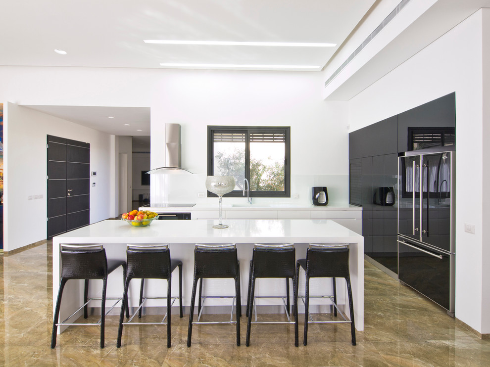 Design ideas for a contemporary u-shaped eat-in kitchen with flat-panel cabinets, black cabinets, white splashback and black appliances.
