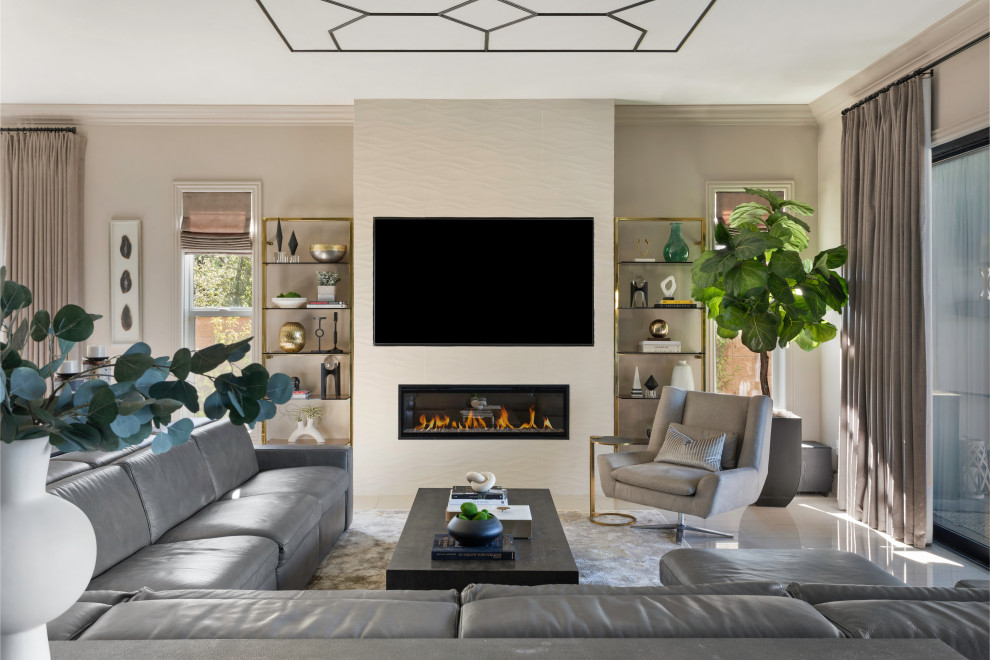 Photo of a large contemporary formal open plan living room in Los Angeles with beige walls, porcelain flooring, a hanging fireplace, a tiled fireplace surround, a wall mounted tv and beige floors.