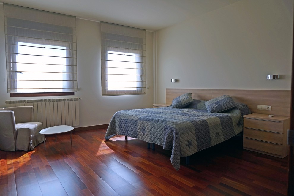 Imagen de dormitorio principal tradicional renovado grande sin chimenea con paredes blancas y suelo de madera oscura