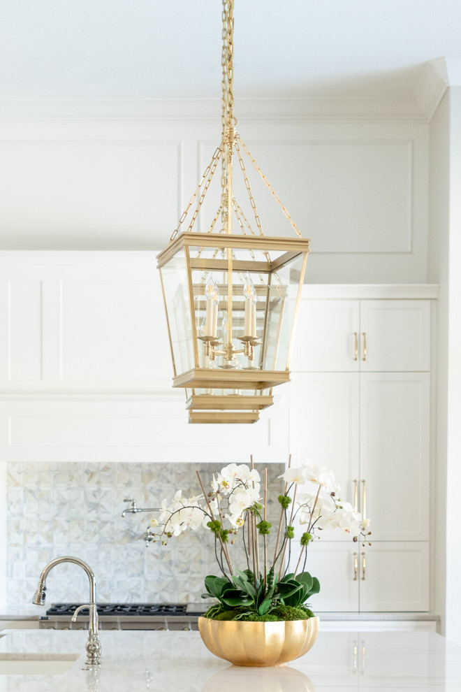 Inspiration for a large transitional porcelain tile and beige floor kitchen remodel in Orlando with a farmhouse sink, recessed-panel cabinets, white cabinets, quartzite countertops, multicolored backsplash, marble backsplash, stainless steel appliances, an island and beige countertops