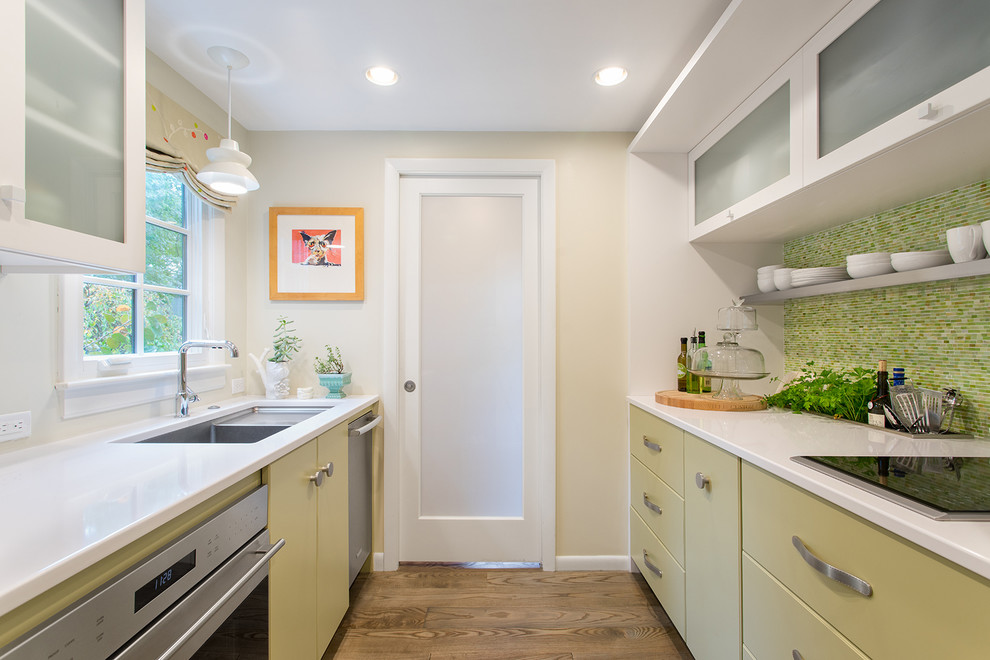 Inspiration for a transitional galley separate kitchen in Boston with an undermount sink, flat-panel cabinets, green cabinets, green splashback, mosaic tile splashback, stainless steel appliances, medium hardwood floors and no island.