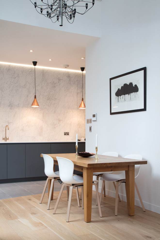 Large contemporary open plan dining in London with concrete floors, grey floor and white walls.
