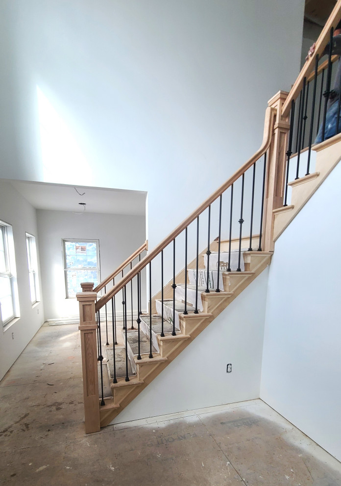 Cette photo montre un grand escalier tendance en L avec des marches en bois, des contremarches en bois et un garde-corps en matériaux mixtes.