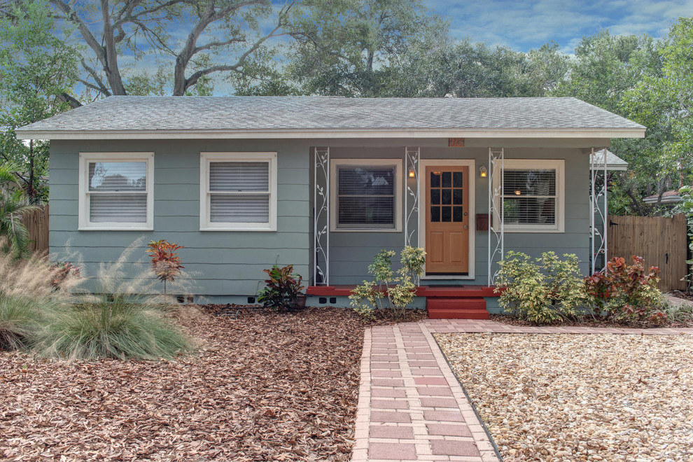This is an example of a mid-sized transitional one-storey grey exterior in Tampa with wood siding and a gable roof.