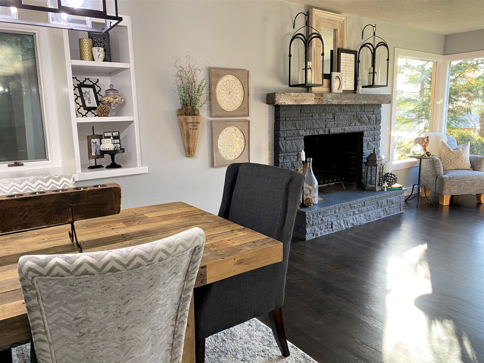 This is an example of a small transitional separate dining room in Portland with grey walls, dark hardwood floors, a standard fireplace, a stone fireplace surround and brown floor.