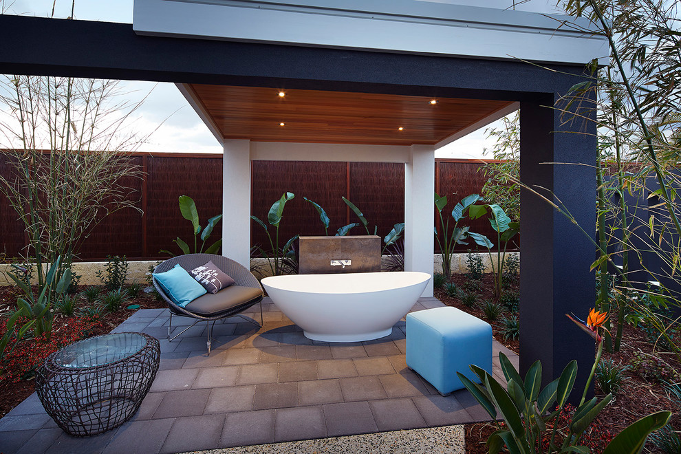Contemporary backyard patio in Perth with natural stone pavers.