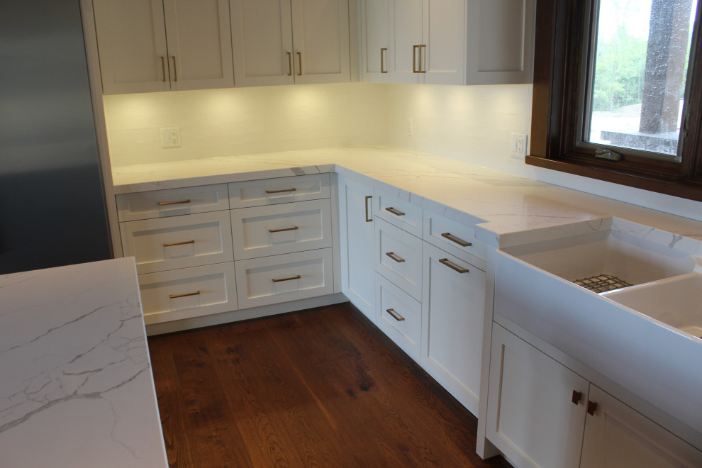 Inspiration for a large rustic u-shaped dark wood floor, brown floor and wood ceiling eat-in kitchen remodel in Toronto with a farmhouse sink, shaker cabinets, white cabinets, quartz countertops, white backsplash, subway tile backsplash, stainless steel appliances, an island and white countertops