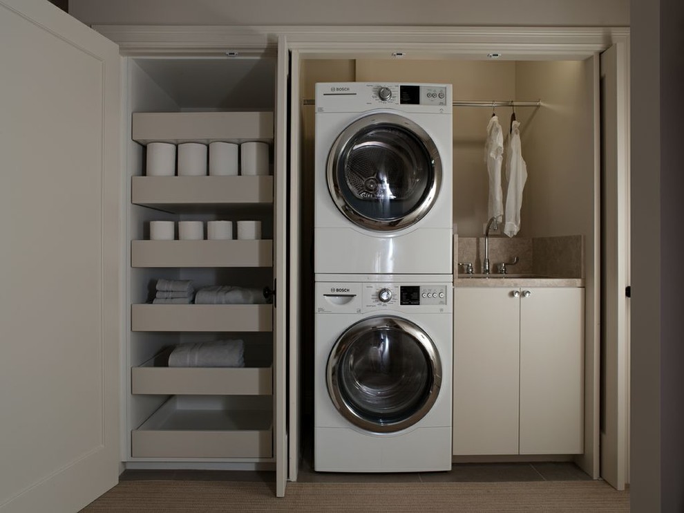 This is an example of a small contemporary single-wall laundry cupboard in San Francisco with a stacked washer and dryer, an undermount sink, flat-panel cabinets, beige cabinets and beige walls.
