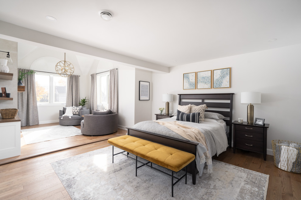 Geräumiges Modernes Hauptschlafzimmer mit grauer Wandfarbe, hellem Holzboden, Kamin, Kaminumrandung aus gestapelten Steinen, braunem Boden und gewölbter Decke in Montreal