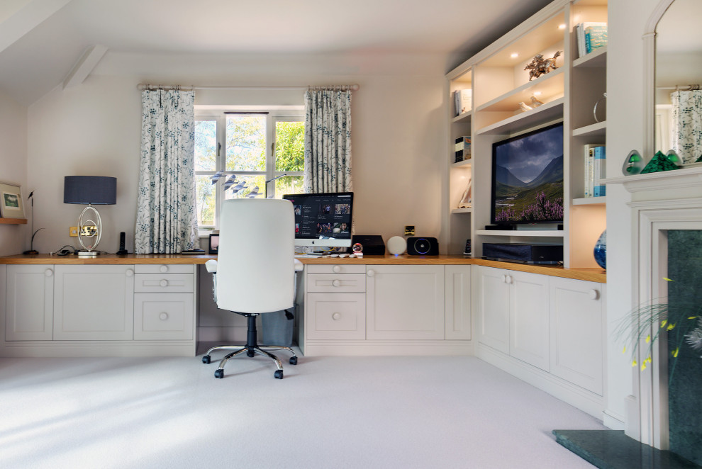 Bild på ett arbetsrum, med beige väggar, en standard öppen spis, en spiselkrans i trä, ett inbyggt skrivbord och vitt golv