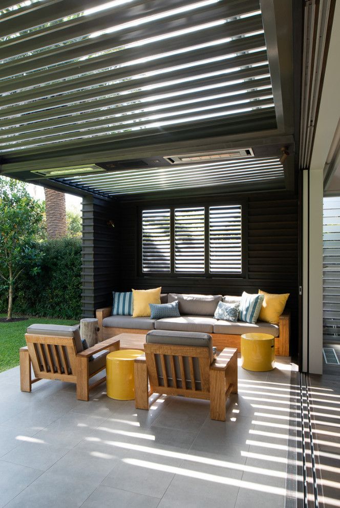 Photo of a large contemporary backyard patio in Sydney with a roof extension.