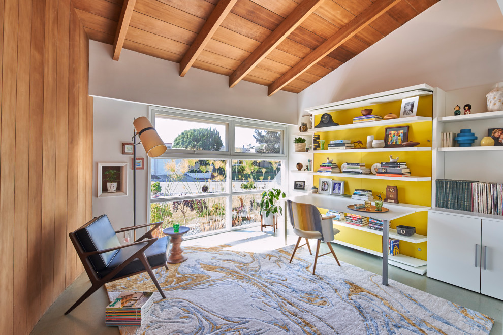 Design ideas for a mid-sized midcentury home office in San Diego with white walls, cork floors, a built-in desk, grey floor, wood walls and vaulted.