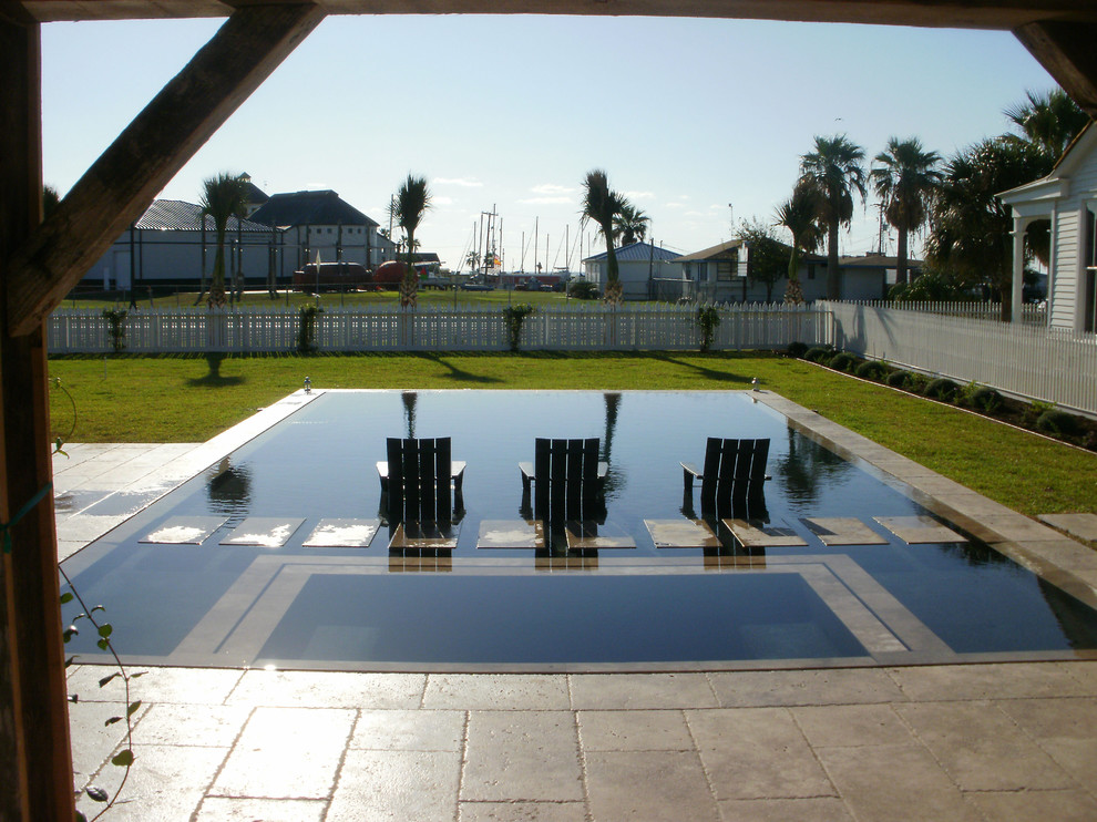 Photo of a mid-sized transitional side yard rectangular lap pool in Austin with natural stone pavers and a hot tub.