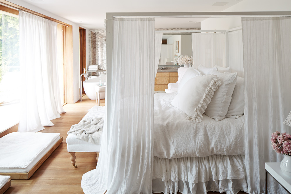 Photo of a traditional master bedroom in Los Angeles with white walls and light hardwood floors.