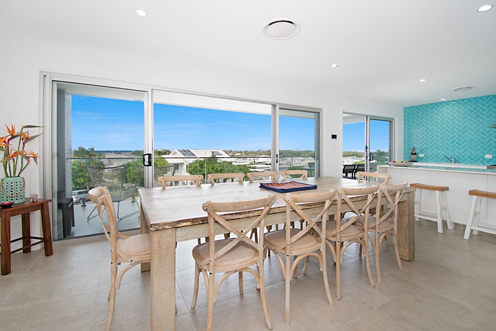 Contemporary open plan dining with white walls, ceramic floors and beige floor.