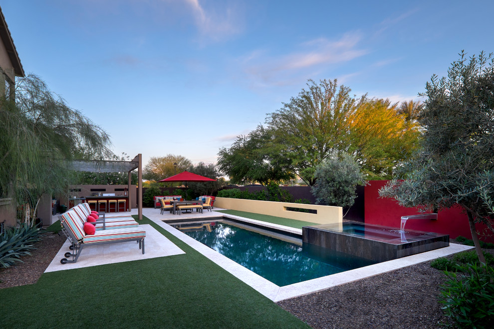 Mid-sized contemporary backyard rectangular pool in Phoenix with a water feature and tile.