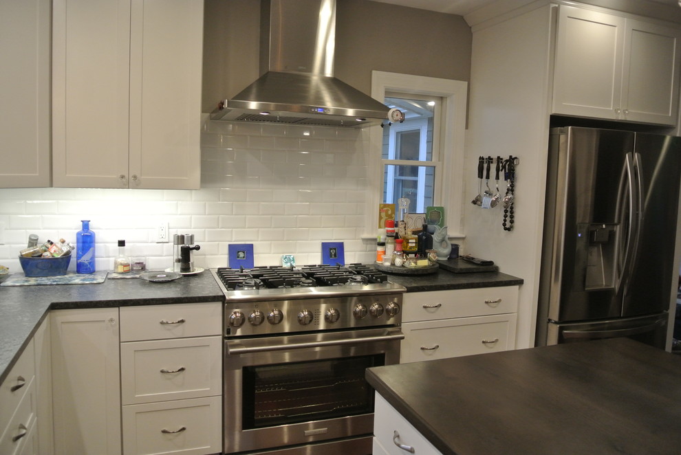 Kitchen - transitional medium tone wood floor kitchen idea in Boston with shaker cabinets, white cabinets, granite countertops, white backsplash, subway tile backsplash, stainless steel appliances and an island