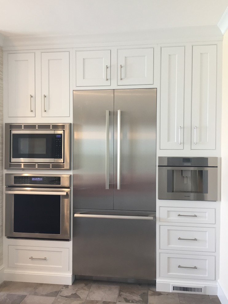 Inspiration for a large transitional ceramic tile and multicolored floor kitchen remodel with a farmhouse sink, beaded inset cabinets, white cabinets, quartz countertops, metallic backsplash, ceramic backsplash, stainless steel appliances and an island