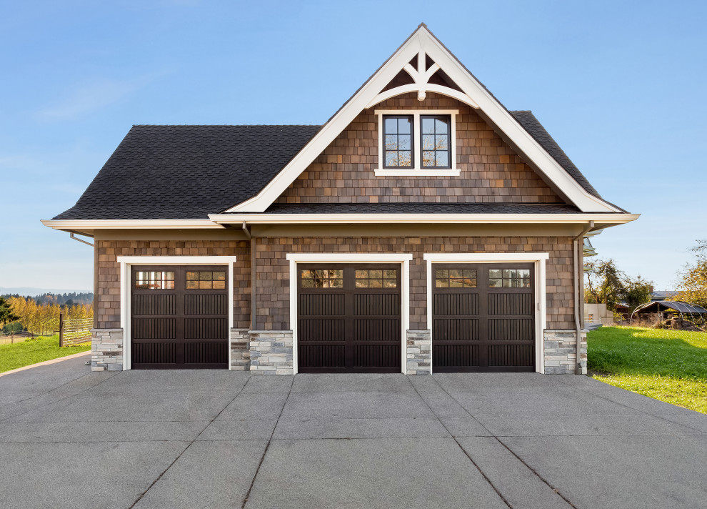 Photo of a large contemporary attached three-car garage in Portland.