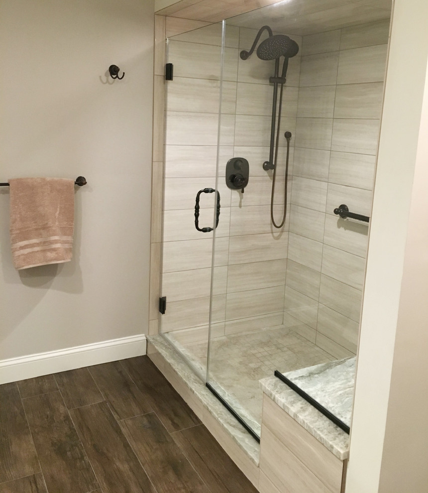Inspiration for a large transitional bathroom in New York with an undermount sink, recessed-panel cabinets, beige cabinets, engineered quartz benchtops, an alcove shower, brown tile, porcelain tile, grey walls, porcelain floors and brown floor.