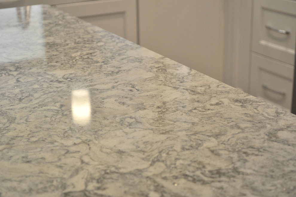 Mid-sized transitional u-shaped eat-in kitchen photo with an undermount sink, shaker cabinets, white cabinets, quartz countertops, white backsplash, marble backsplash, stainless steel appliances and no island