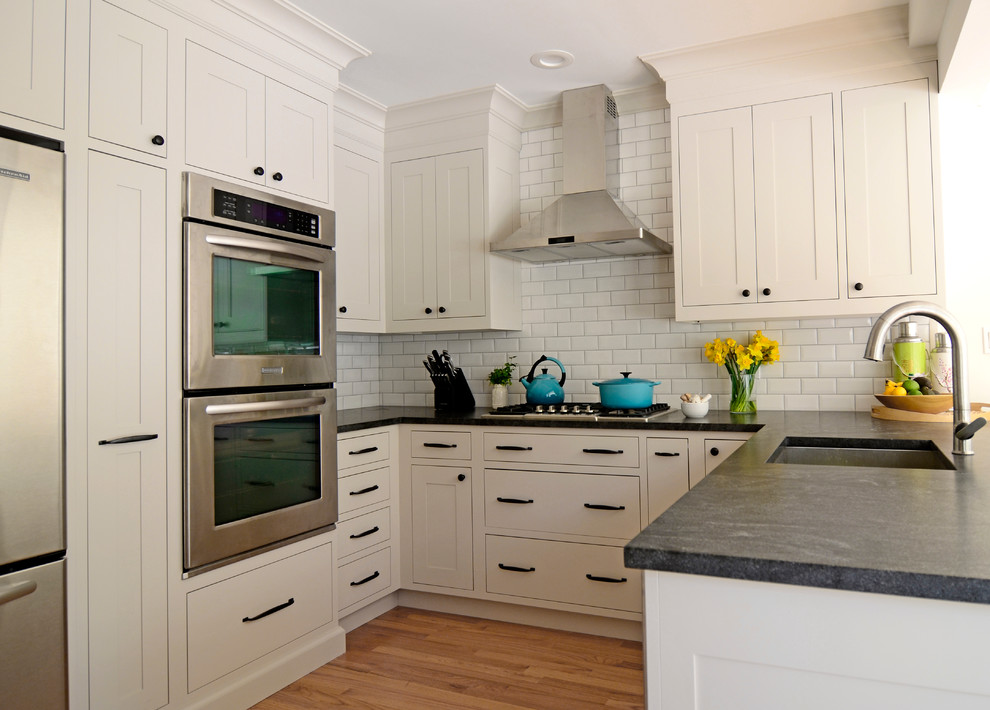 Design ideas for a small traditional u-shaped eat-in kitchen in New York with an undermount sink, shaker cabinets, beige cabinets, granite benchtops, white splashback, stainless steel appliances, a peninsula and subway tile splashback.
