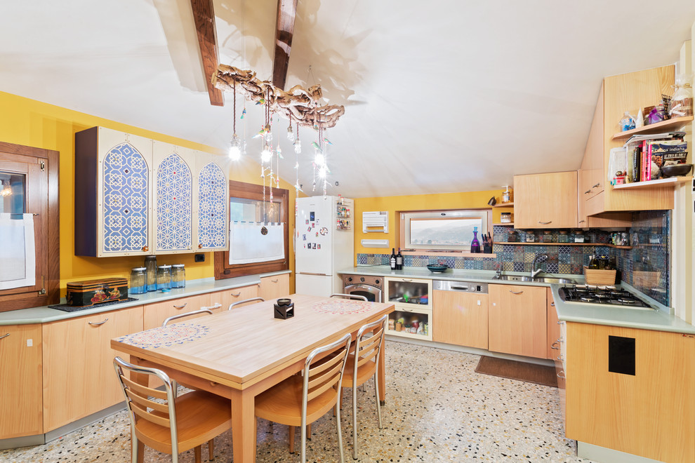 This is an example of a mediterranean u-shaped eat-in kitchen in Venice with a double-bowl sink, flat-panel cabinets, medium wood cabinets, multi-coloured splashback, stainless steel appliances, terrazzo floors, multi-coloured floor and green benchtop.