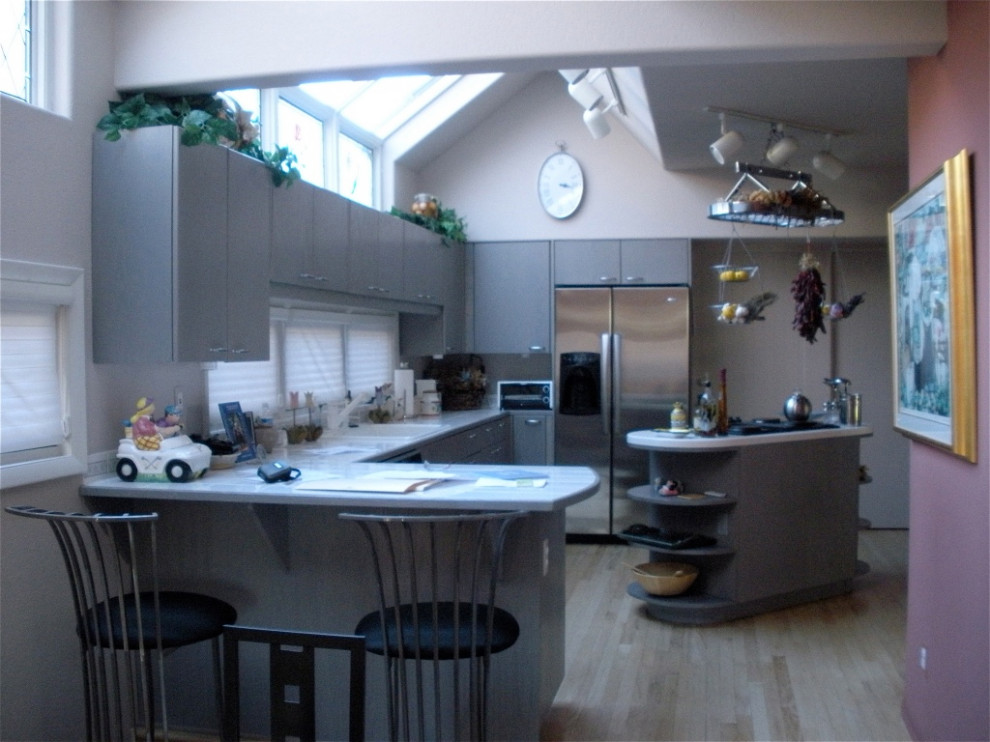 Geschlossene, Mittelgroße Moderne Küche mit flächenbündigen Schrankfronten und Kücheninsel in Denver
