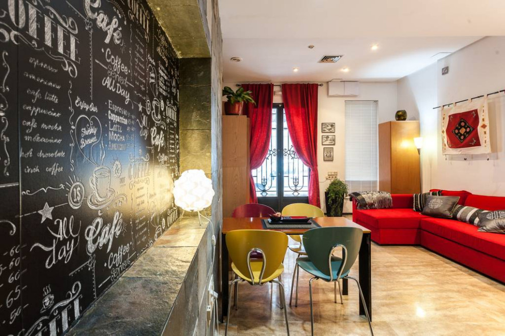 Réalisation d'une petite salle à manger design avec une banquette d'angle, un mur multicolore, un sol en travertin et un sol marron.