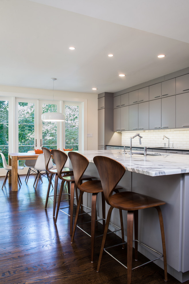 Contemporary single-wall eat-in kitchen in DC Metro with an undermount sink, flat-panel cabinets, grey cabinets, marble benchtops, white splashback, ceramic splashback and stainless steel appliances.