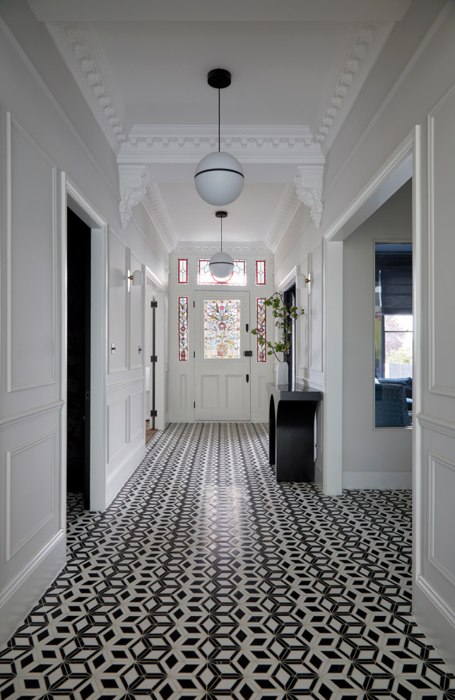 На фото: огромный коридор в современном стиле с белыми стенами, полом из керамической плитки и черным полом с
