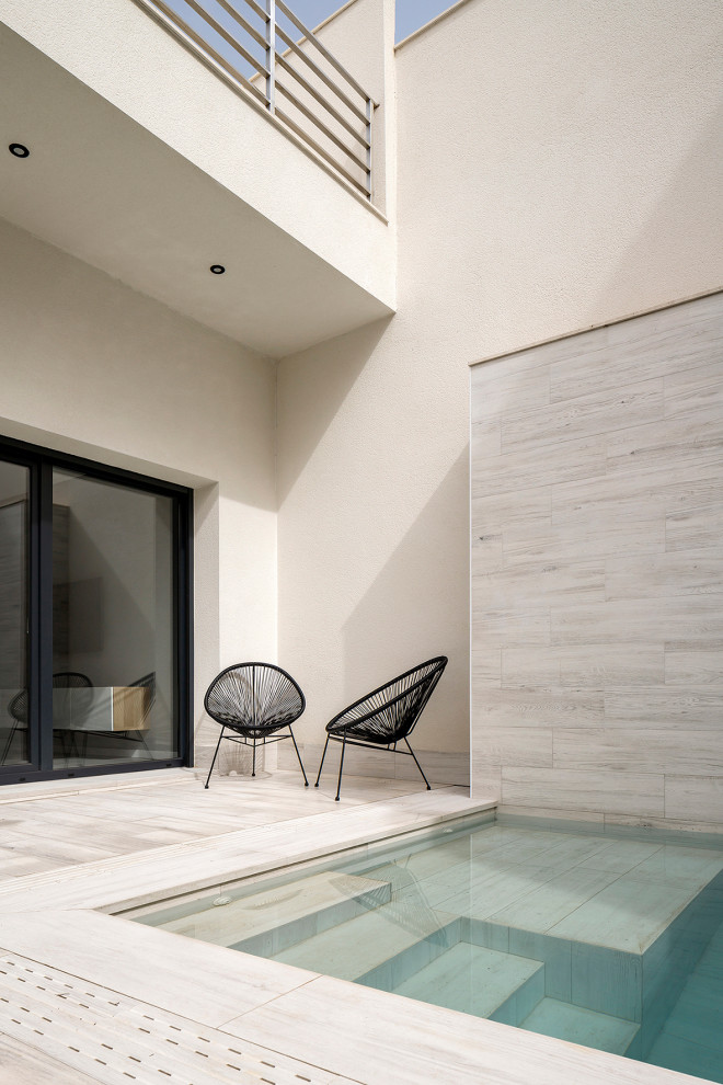 Ispirazione per una piscina monocorsia moderna rettangolare di medie dimensioni e dietro casa con paesaggistica bordo piscina e piastrelle